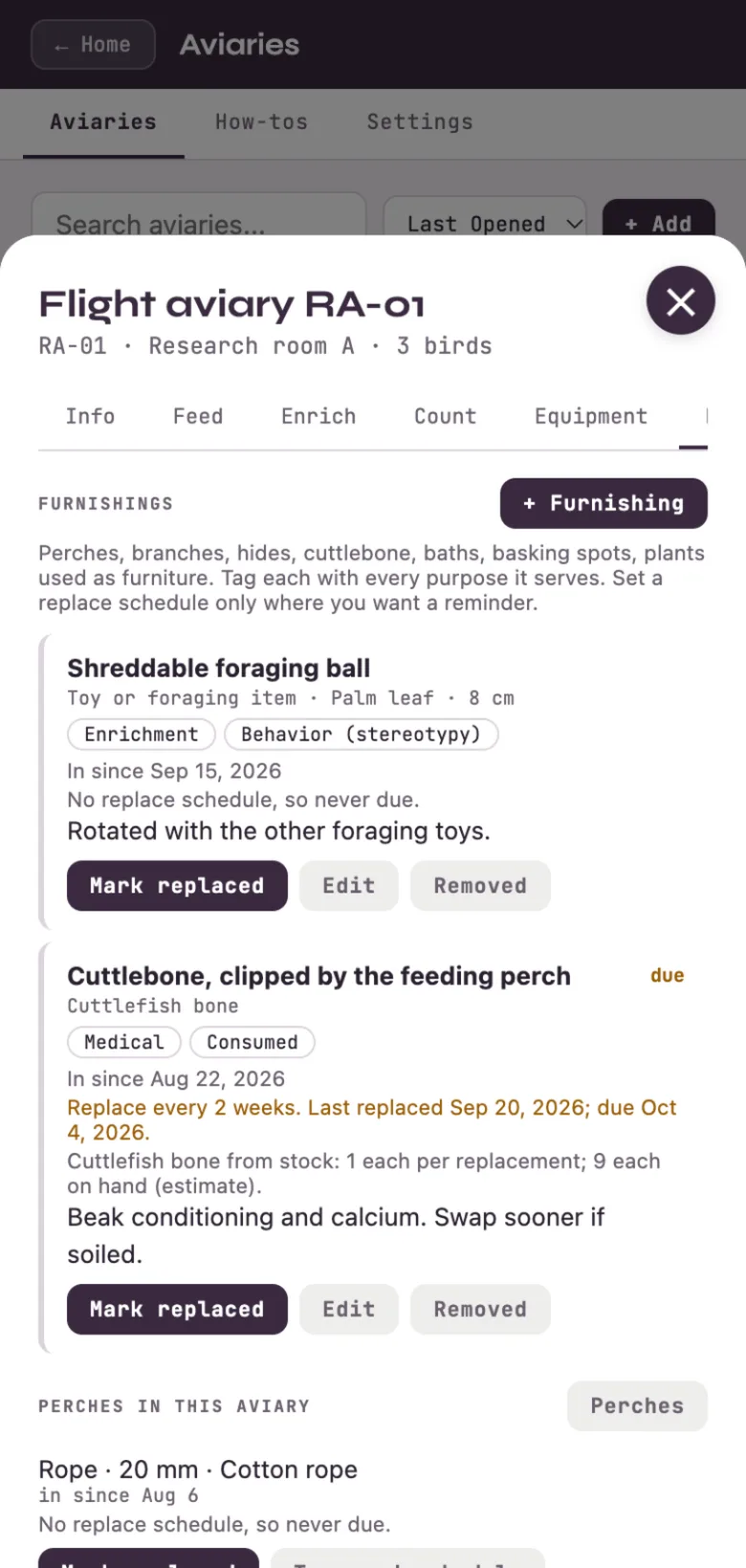 An aviary's Furnishings tab: a foraging ball and a cuttlebone with tags, a replace schedule and stock on hand.